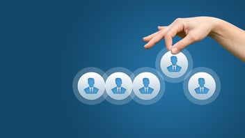 Mano seleccionando un perfil profesional de un grupo, simbolizando el proceso de reclutamiento y selección de talento calificado por una empresa de reclutamiento como People Care para cubrir vacantes rápidamente.