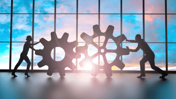 Dos líderes uniendo engranes, representando cómo la planeación de RH integra presupuesto, personal y KPIs con los objetivos de la empresa.