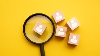 Lupa enfocando al candidato ideal entre varios perfiles, ilustrando una estrategia de Employer Branding en México para atraer talento y reducir la rotación.
