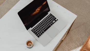 Laptop sobre escritorio minimalista con café, representando la planificación estratégica y gestión de la jornada laboral para optimizar la productividad y eficiencia operativa en empresas de México.