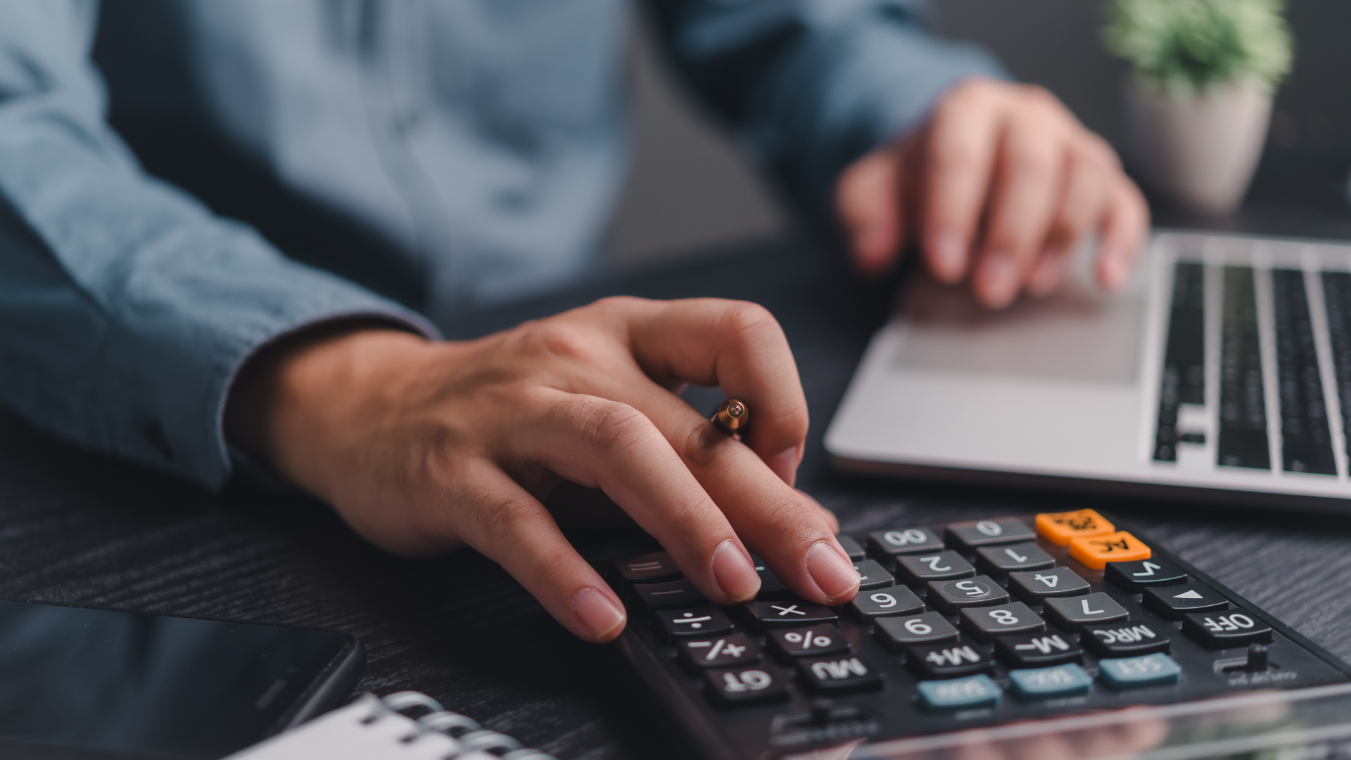 Gerente de Recursos Humanos usando una calculadora para analizar los costos ocultos de la nómina interna y el cumplimiento de normativas como la NOM-035 en México.