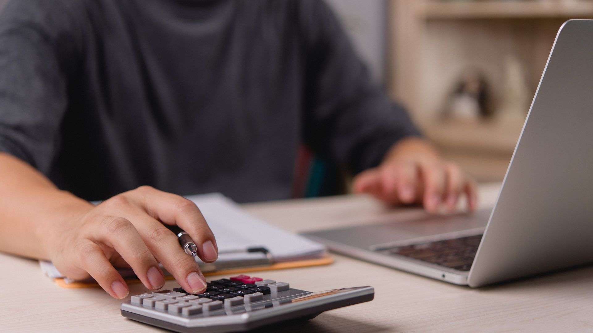 Profesional de Recursos Humanos utilizando una calculadora y laptop para gestionar el cálculo de PTU y la Declaración Anual, optimizando procesos de nómina y cumplimiento normativo en México.