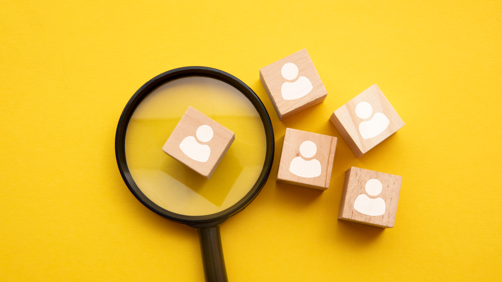 Lupa enfocando al candidato ideal entre varios perfiles, ilustrando una estrategia de Employer Branding en México para atraer talento y reducir la rotación.